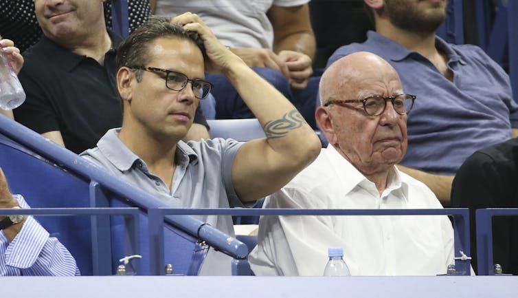 Two men at a sports game, one younger and one older.