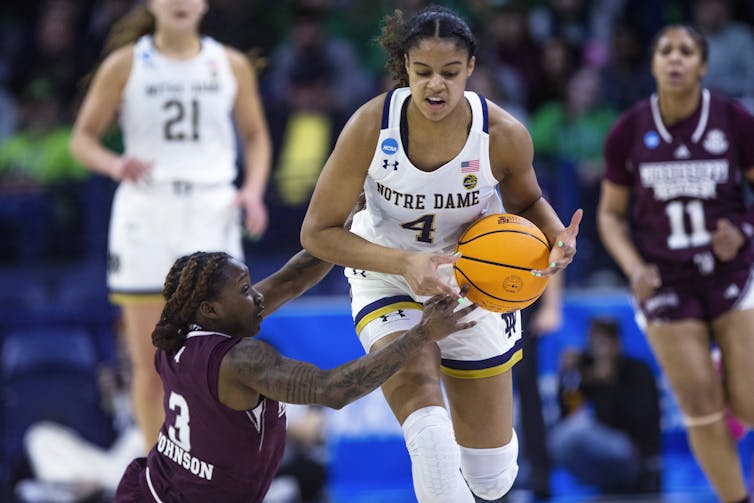 Two women playing basketball