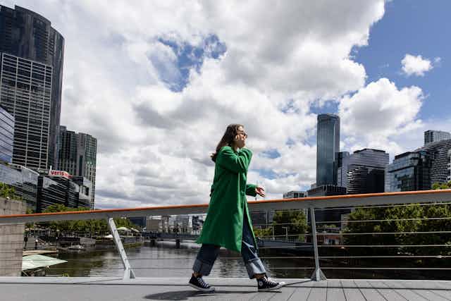 woman walks with gathering clouds behind