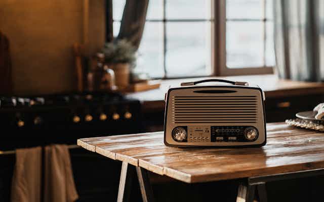 An FM radio on a trestle table in a kitchen.
