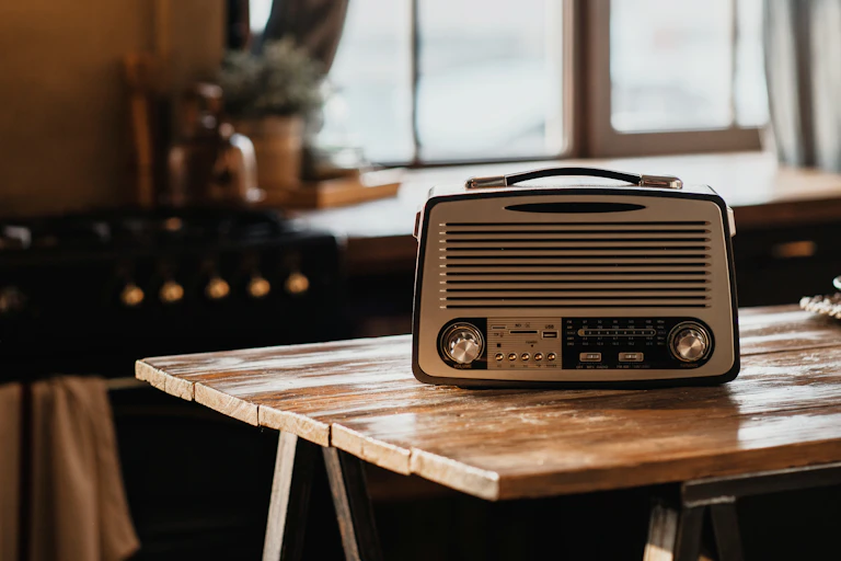An FM radio on a trestle table in a kitchen.
