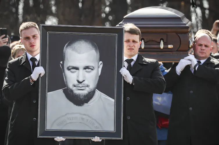 Mourners carry a coffin and a portrait of Vladlen Tatarsky.