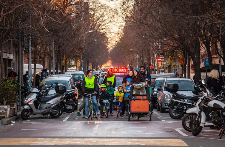 Un grupo de niños y adultos en bicicleta por la ciudad.