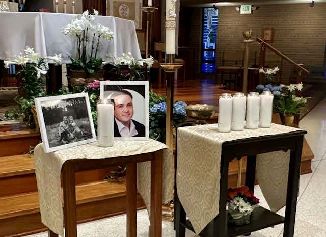 A memorial set up on two tables for a man whose picture is in a frame.