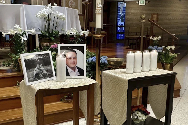 A memorial set up on two tables for a man whose picture is in a frame.