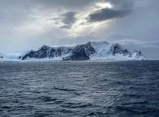 A view across water to Antarctic islands, covered with ice and snow.