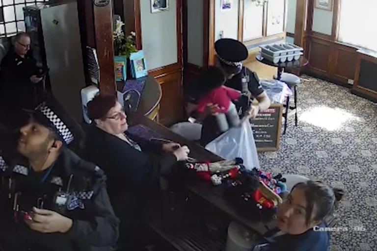 A still from CCTV footage of police putting golliwog dolls in a plastic bag in a pub.