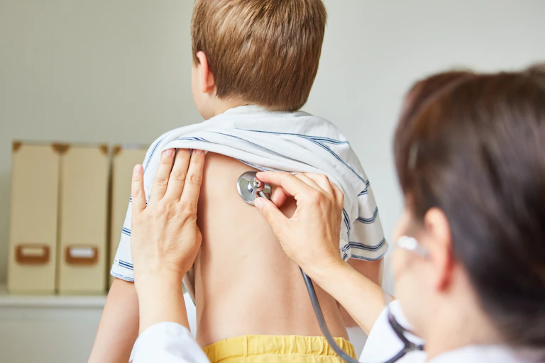 Doctor listens to child's chest