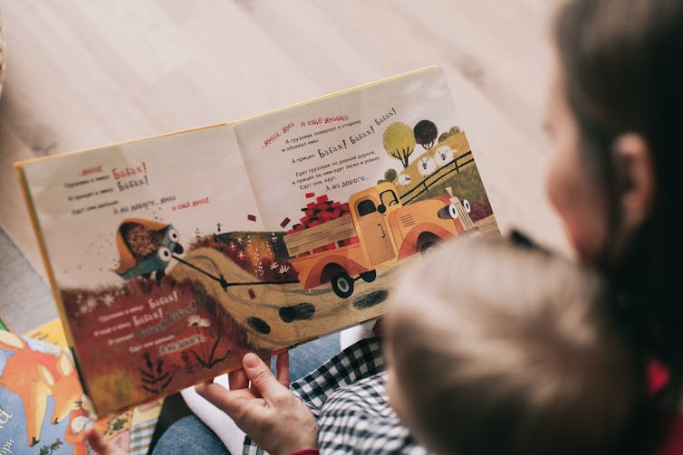 A woman reading to a baby.