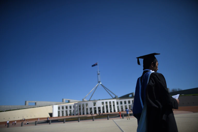 A graduate in the forecourt of Parliament House in Canberra.