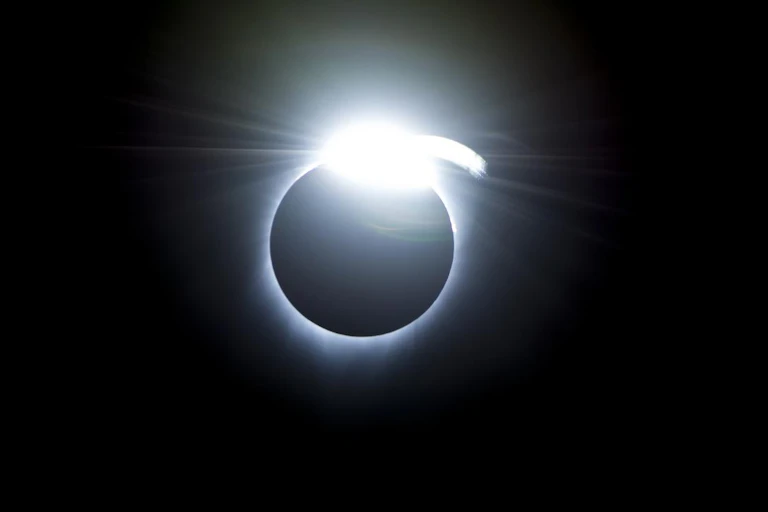 A black circle with a bright white outline and a shining spot on top