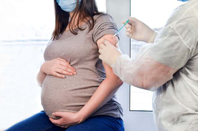 pregnant person gets injection in arm