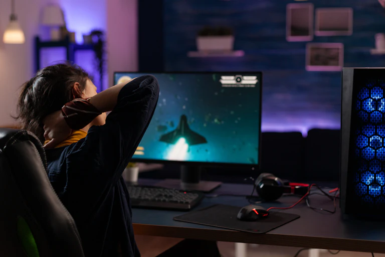 Une jeune femme en pleine partie de jeu vidéo se masse la nuque