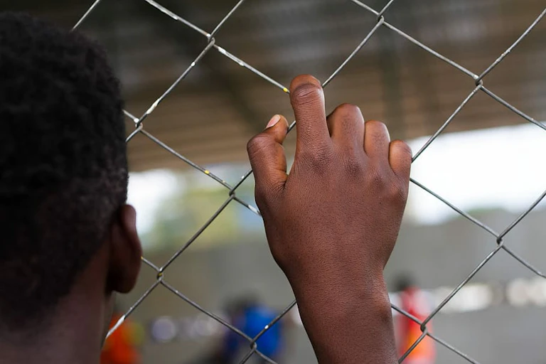 A child behind a wire barricade
