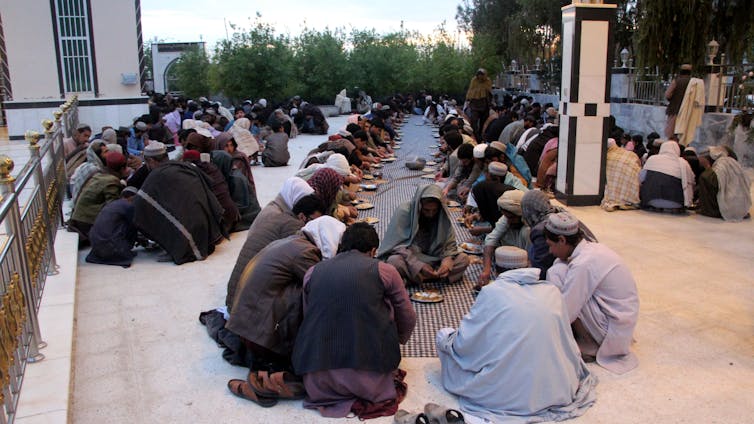 Afghanista muslims sit down to Ramadan breakfast in Kandahar, APril 2023.