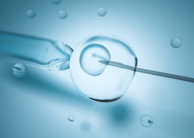 a needle is injected into a cell on a blue background