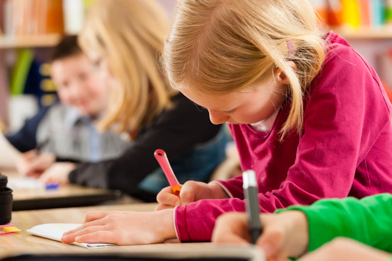 Élèves de l'école primaire qui font leurs devoirs ou passent un examen scolaire