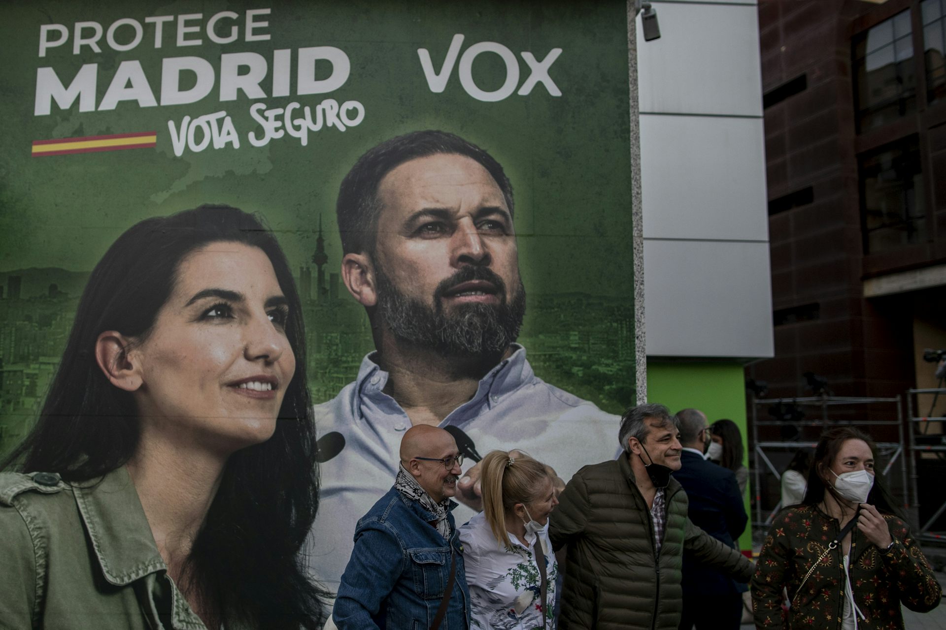 Des personnes passent devant une affiche électorale