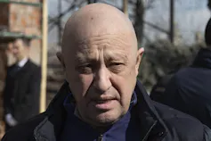 A bald man in a dark coat.