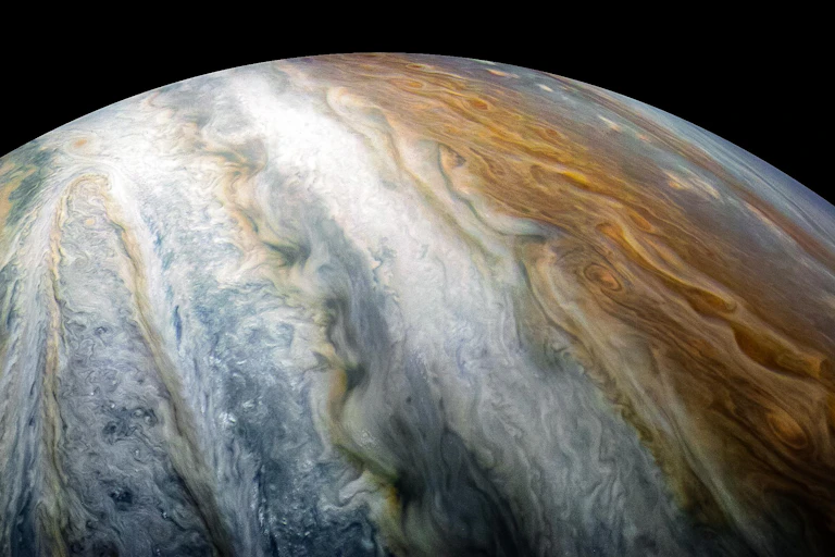 A half sphere with swirling orange, white and grey bands running across it