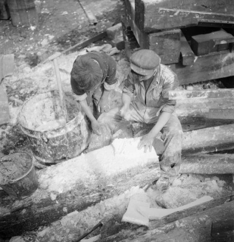 Two young workers mixing asbestos insulation