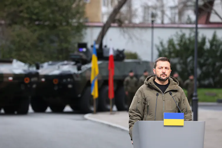 Ukrainian presidennt Volodymyr Zelensky stands at a podium to deliver a speech.