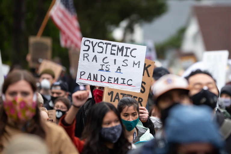 Une manifestante brandi une pancarte dénonçant le racisme systémique à Seattle, États-Unis, le 12 juin 2020.