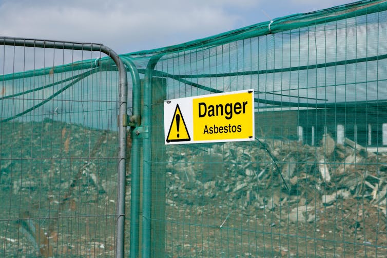 Warning sign on a fenced-off school demolition site