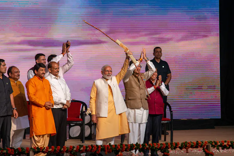 Le premier ministre Narendra Modi tient un arc et une flèche pendant les célébrations de Dussehra à Dwarka