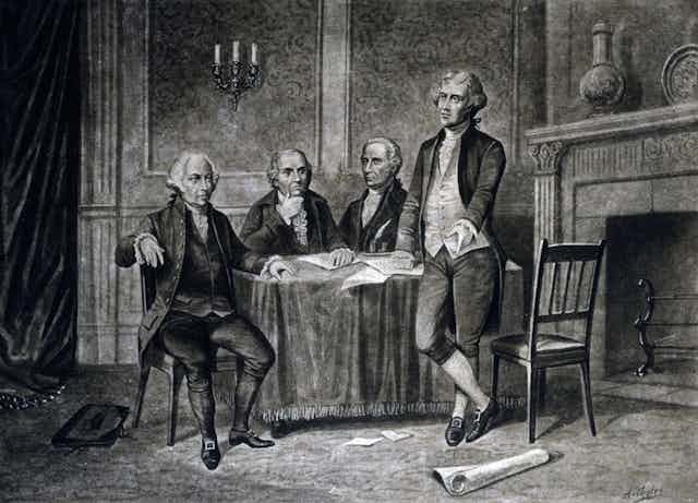Four older men of the 18th century, around a table.