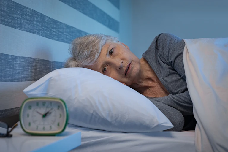 femme âgée réveillée dans son lit