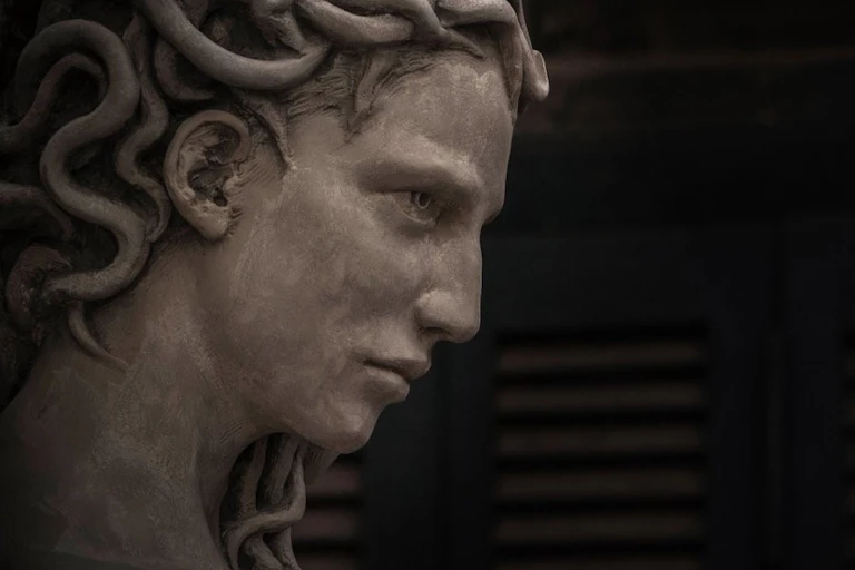 A sculpture showing a woman's face with braided hair.