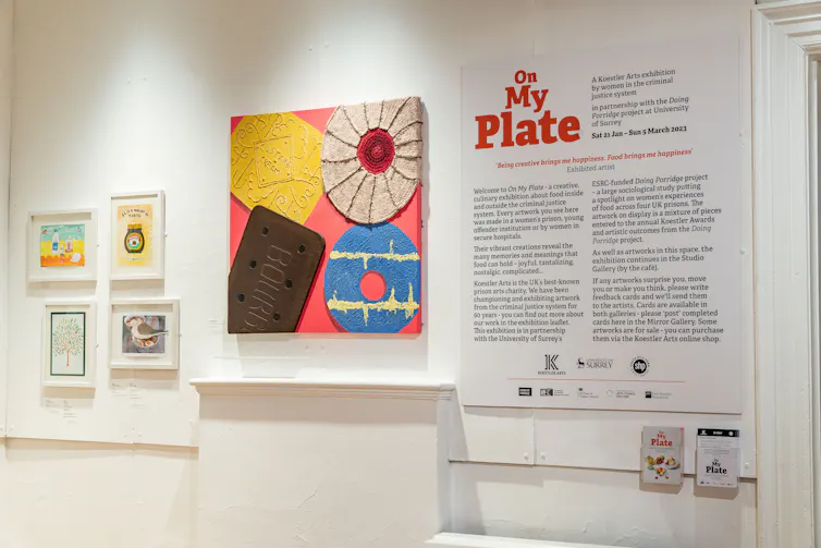 Infographic signs for the On My Plate exhibition hung on a white wall.