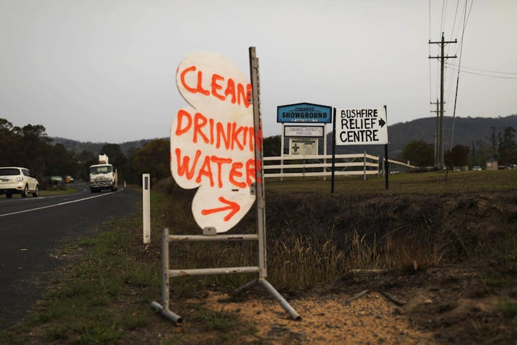 A makeshift sign by the side of the road directs people to clean drinking water at the Bushfire Relief Centre