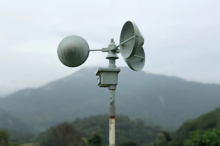 A powder coated metal contraption with three conical cups on a pole