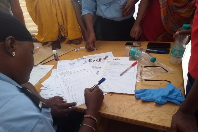 A policewoman writing on a table with people standing