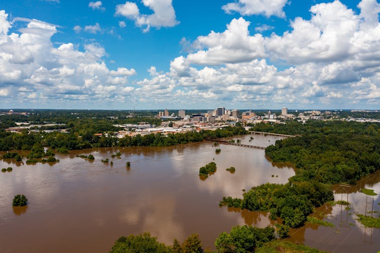 Rio inundado com cidade ao fundo