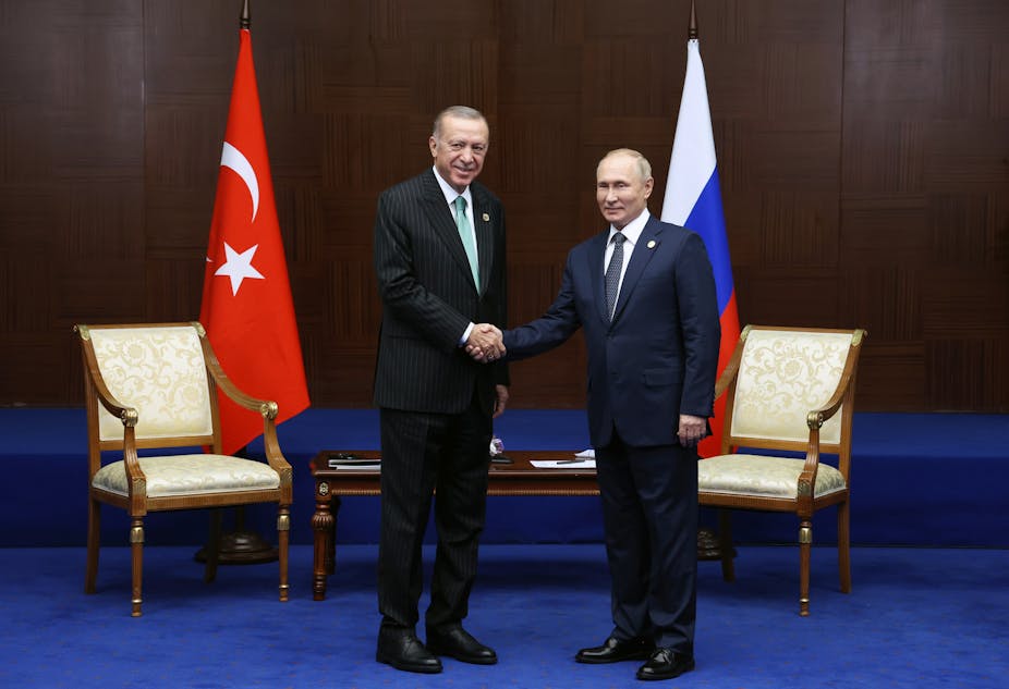 Recep Tayyip Erdogan et Vladimir Poutine se serrent la main.