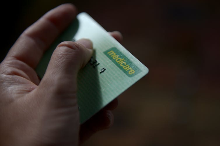 Person hands over Medicare card
