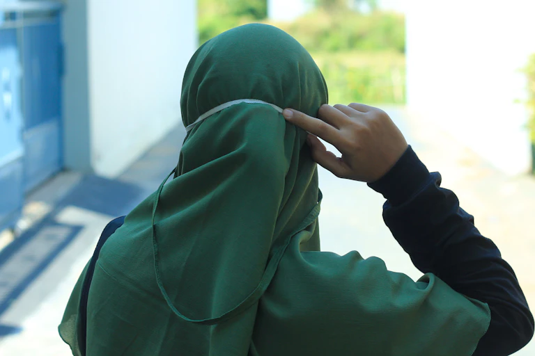 Head and shoulders of woman wearing headscarf, seen from behind