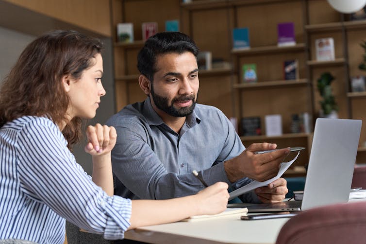 Two teachers discuss work together.