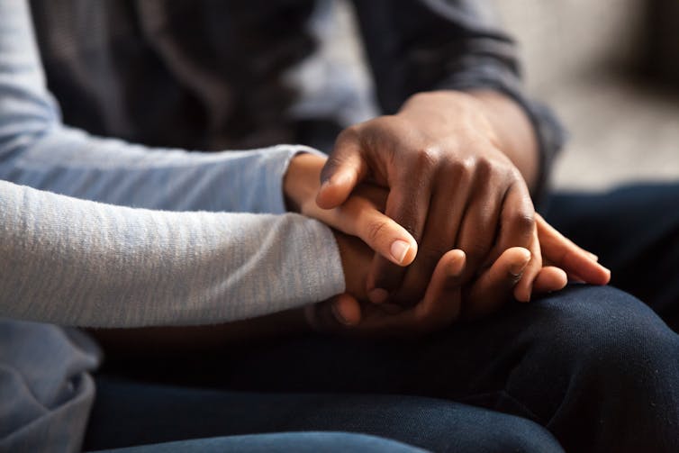 Two people hold hands.