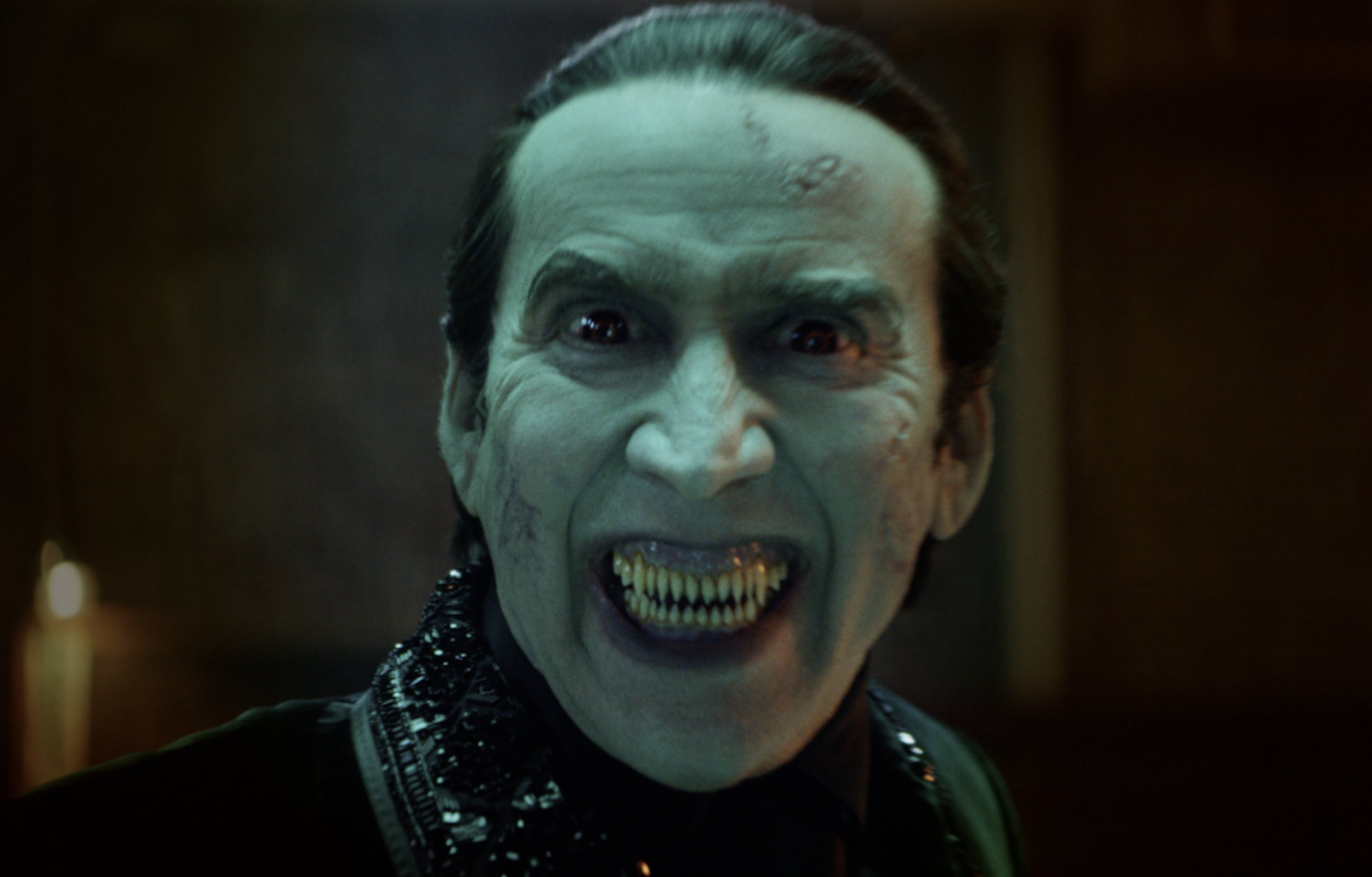 Close up of Nicolas Cage as Dracula, fangs bared.