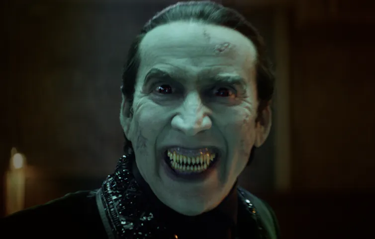 Close up of Nicolas Cage as Dracula, fangs bared.