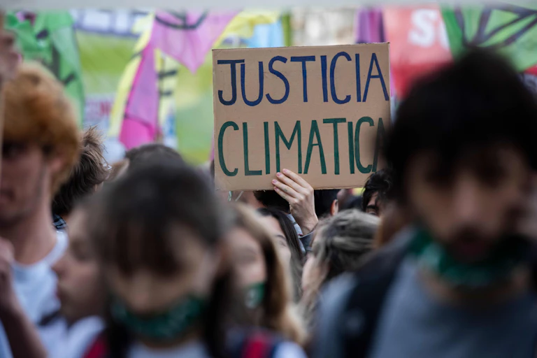 Manifestante sujeta un cartel que reza "justicia climática".