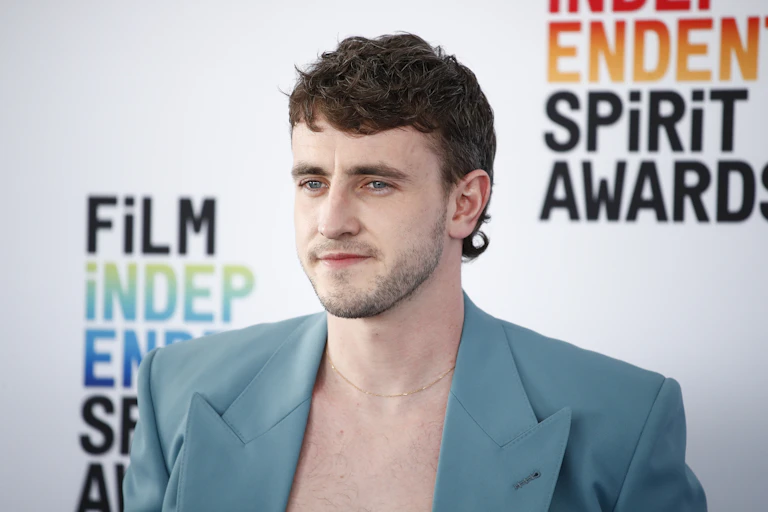 Irish actor Paul Mescal wearing a mullet hairstyle and open blue suit jacket.