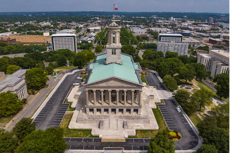 A large, columned building with a green roof and cupola.