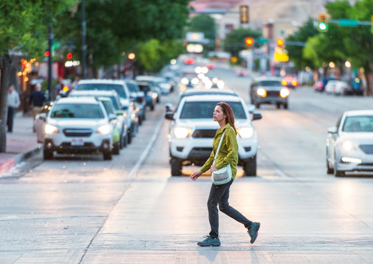 Pedestrian crosses street in front of cars