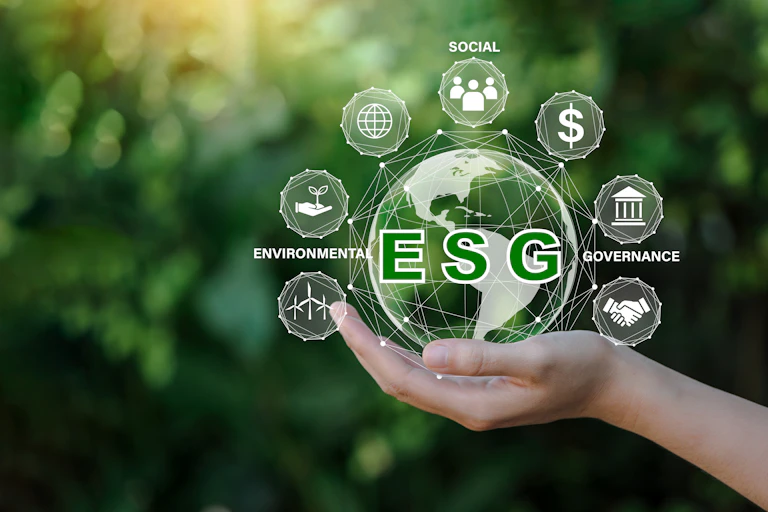 A hand holding a globe with ESG factors