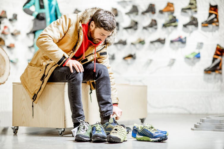 A man trying on a pair of shoes in a shoe store.